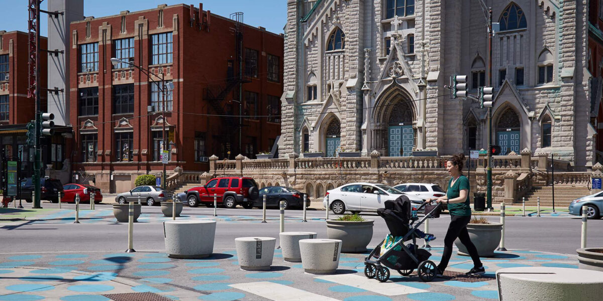Women with stroller crossing in crosswalk