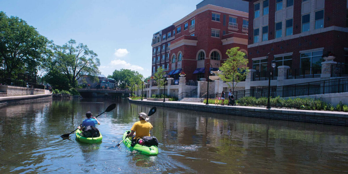 Kayaks on river in city area.